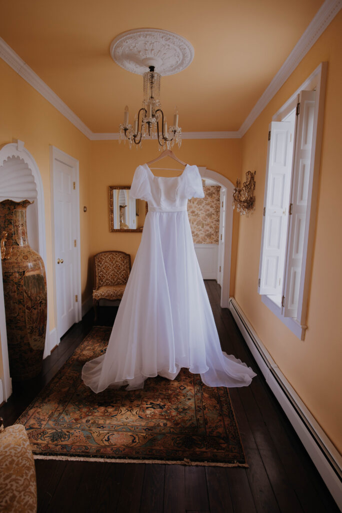 wedding dress on hanger in getting ready room