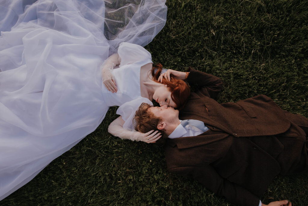 bride and groom laying on lawn at Heigh Torr Estate wedding venue