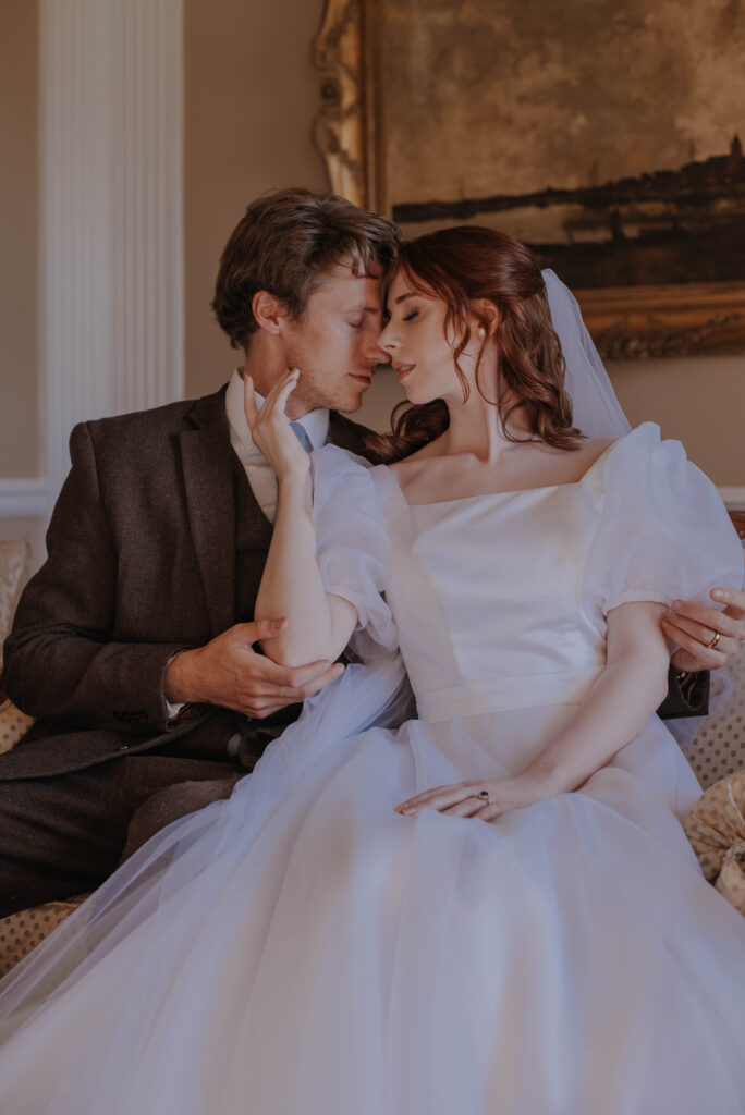 bride and groom have romantic moment on couch