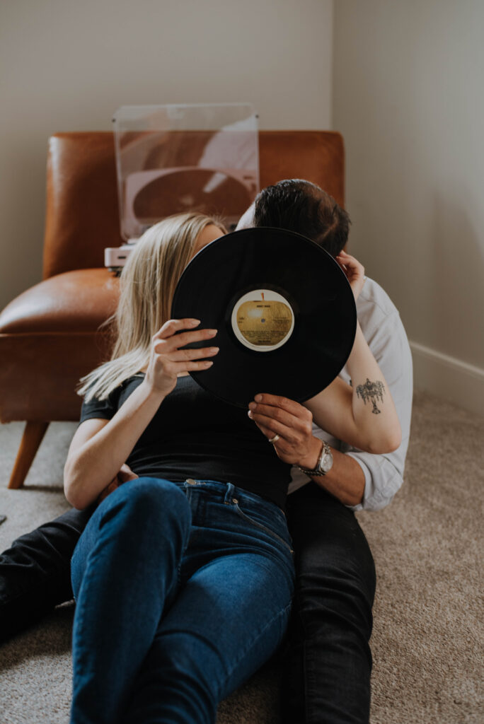 Couple kissing behind a record