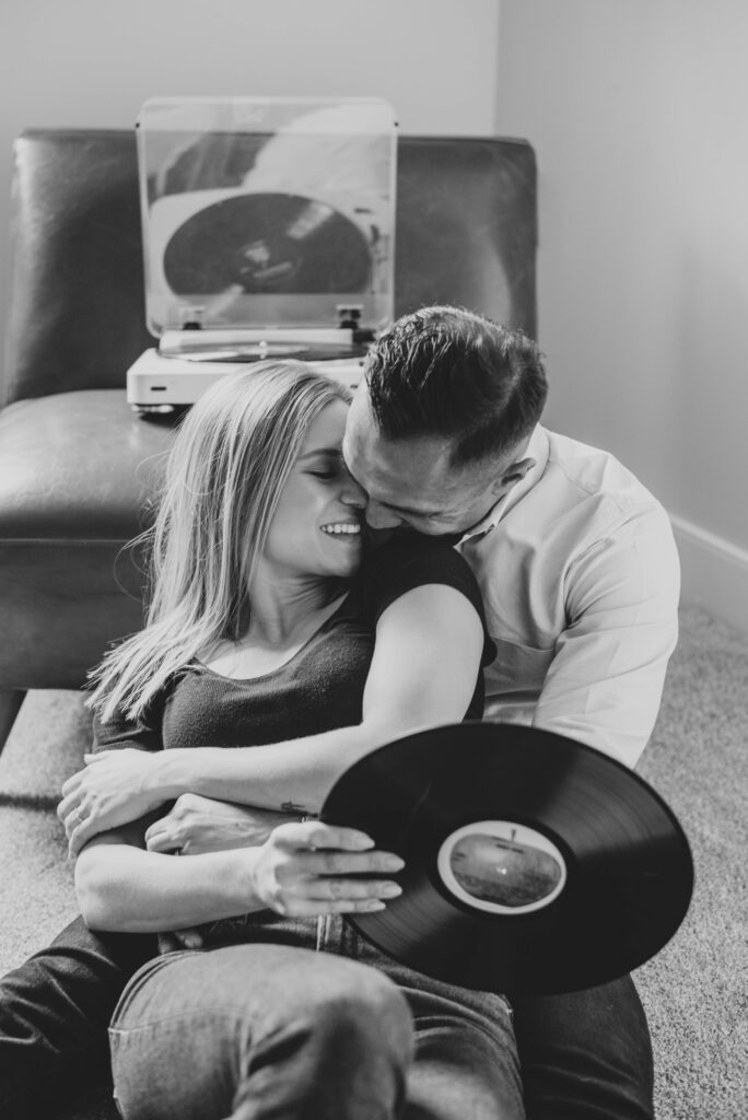 Couple snuggling at home with record player