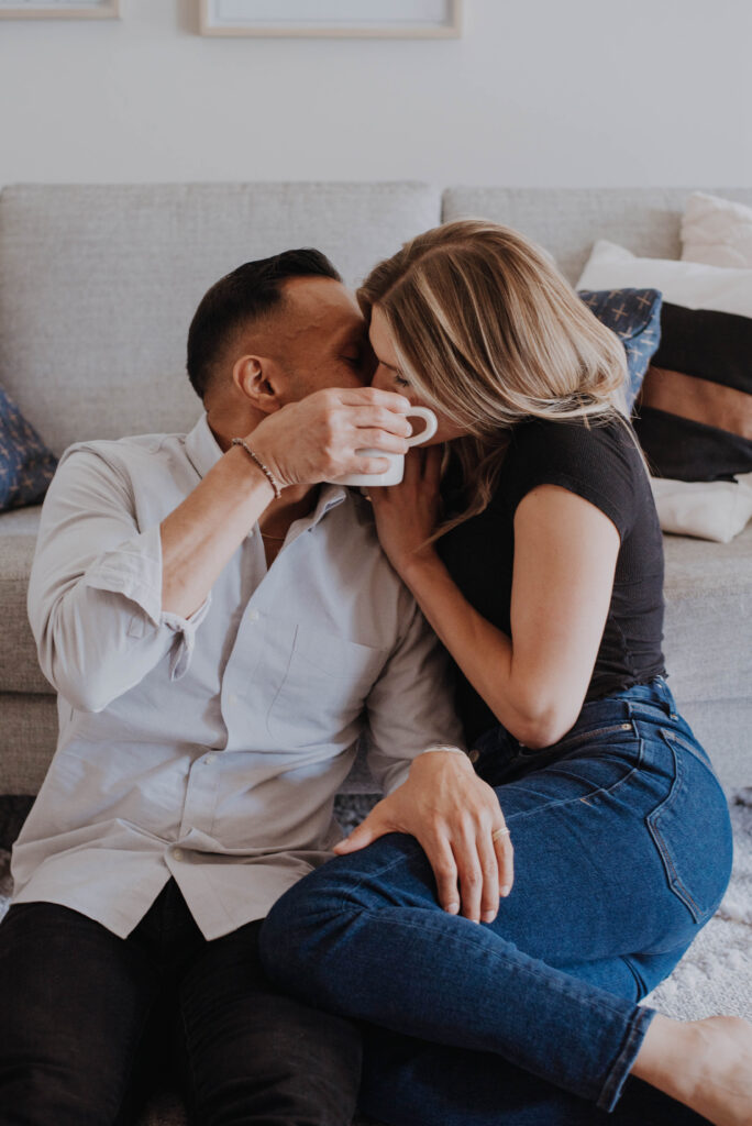 Couple kissing behind coffee cup