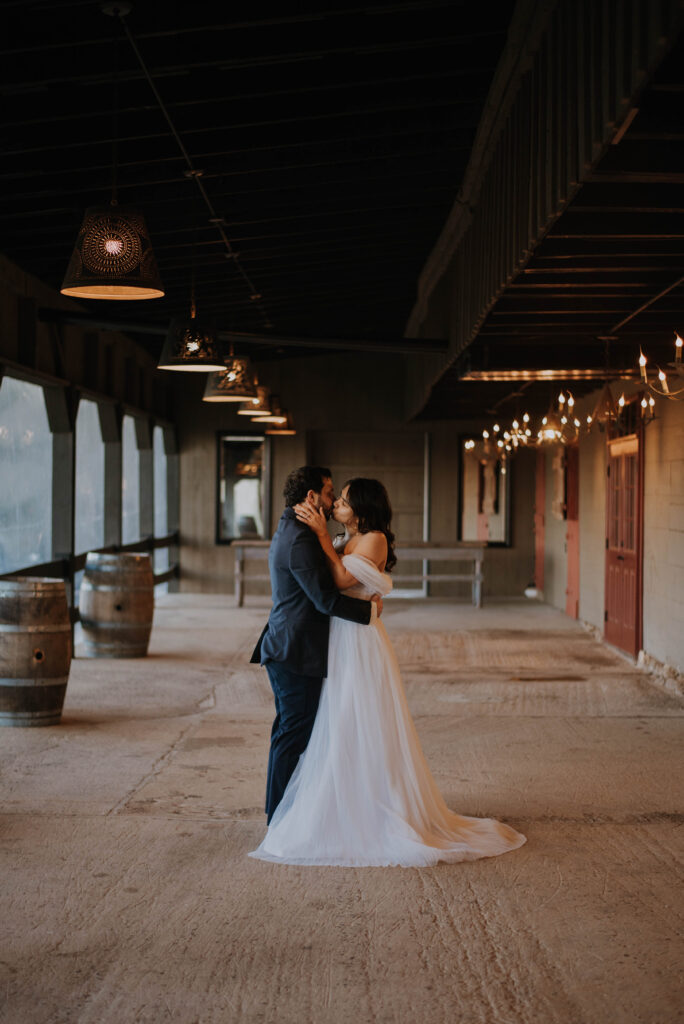 bride and groom kiss at barn wedding venue in VA