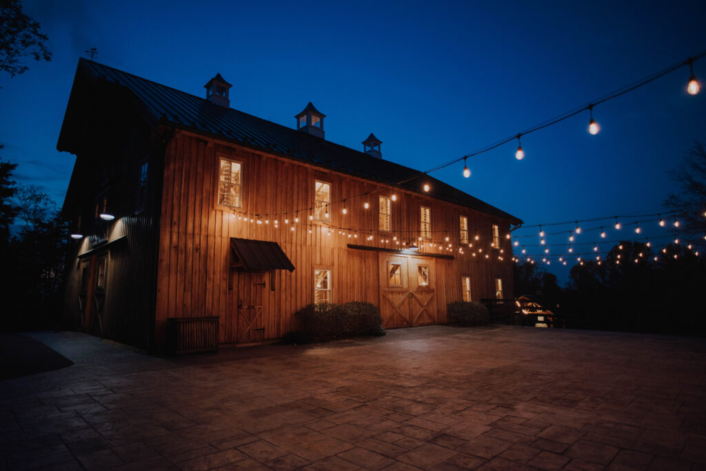 The Oak Barn at Loyalty at night with string lights outside