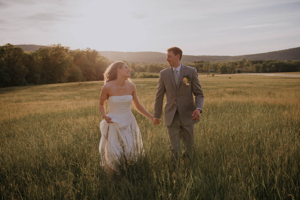 Bride & Groom running in a field at Heigh Torr Estate